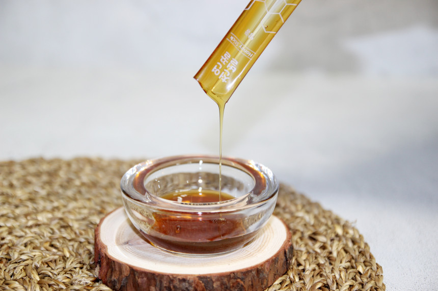 천연벌꿀스틱에서 꿀을 따르는 사진