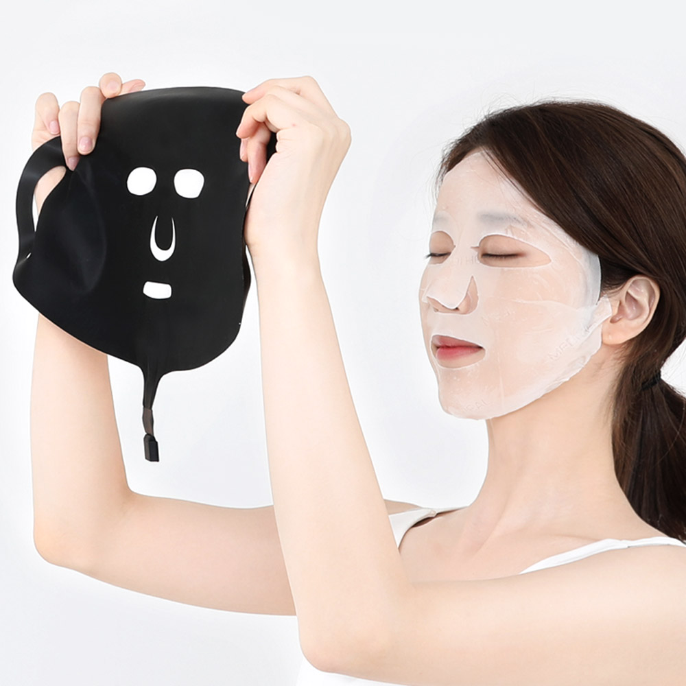 검은색 히팅마스크를 손에 들고 있는 모습으로 마스크의 구부러지는 텍스처와 아이홀, 입홀 오픈 디자인이 보임
