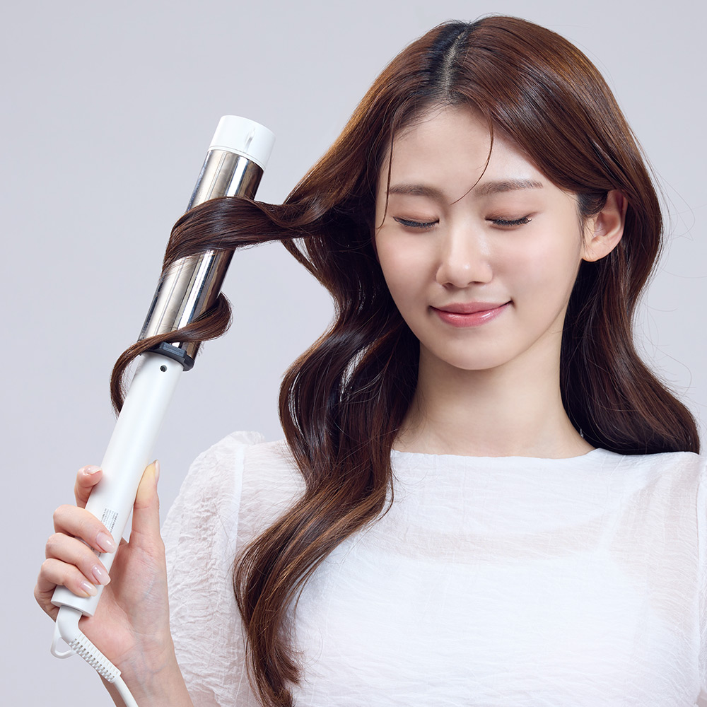봉고데기로 머리카락을 감싸 웨이브를 만드는 사용 모습을 보여주는 중앙 클로즈업