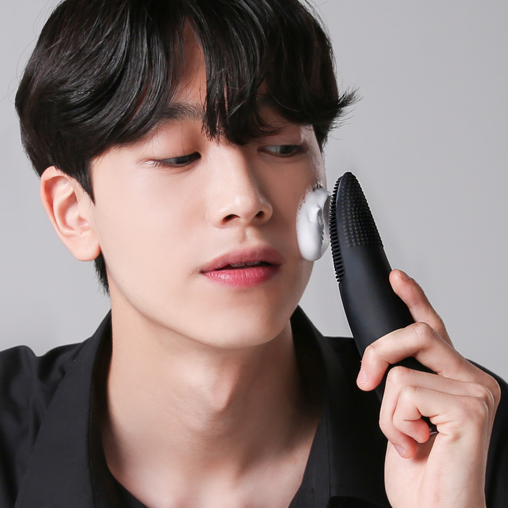 남성이 얼굴 옆면에 클렌저를 갖다대고 사용하는 장면