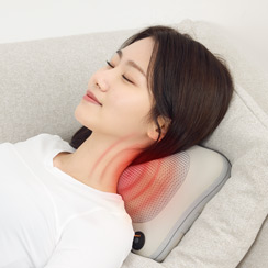 침대에 누워 목 뒤쪽에 마사지 쿠션을 대고 온열 마사지를 받는 사람의 옆모습