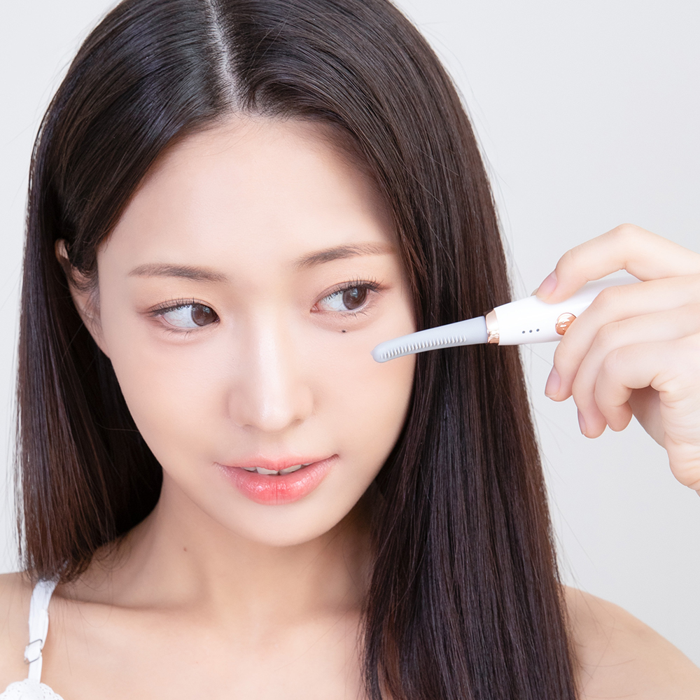 여성이 손에 들고 속눈썹 고데기를 눈썹에 적용하는 각도를 측면에서 촬영한 이미지