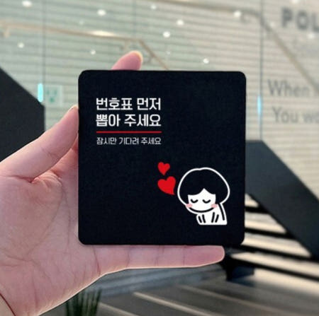 복지관 번호표 뽑아주세요 인사하는 직원 표지판