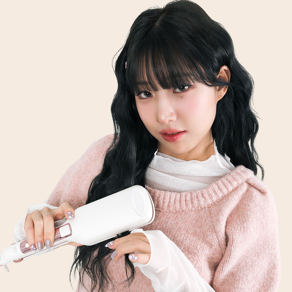 물결 웨이브가 드러난 흑발의 단발머리 스타일을 고데기로 연출하는 여성의 사용 장면