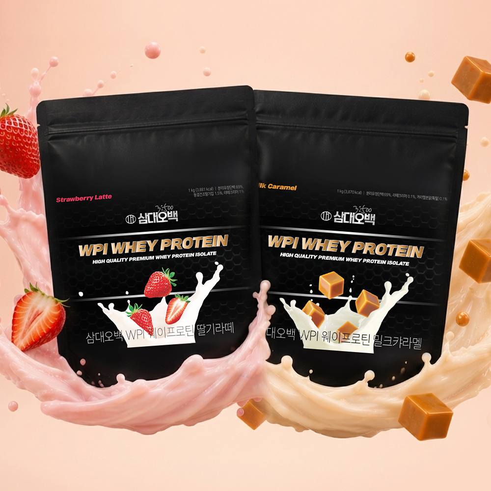 검은색 포장의 딸기라떼와 캐러멜 맛 WPI 웨이 프로틴 두 봉지가 분홍색과 캐러멜색 우유 물결 위에 놓여 있으며, 실제 딸기와 캐러멜 큐브, 핑크 구슬 장식이 배경에 배치된 스튜디오 촬영 이미지